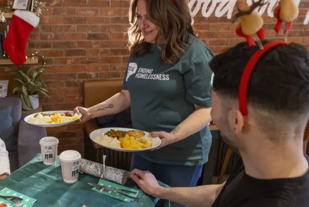 A woman serves Christmas dinner to people in a cafe